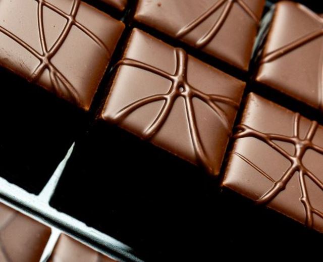 Gros plan sur des carrés de chocolat noir avec motif décoratif