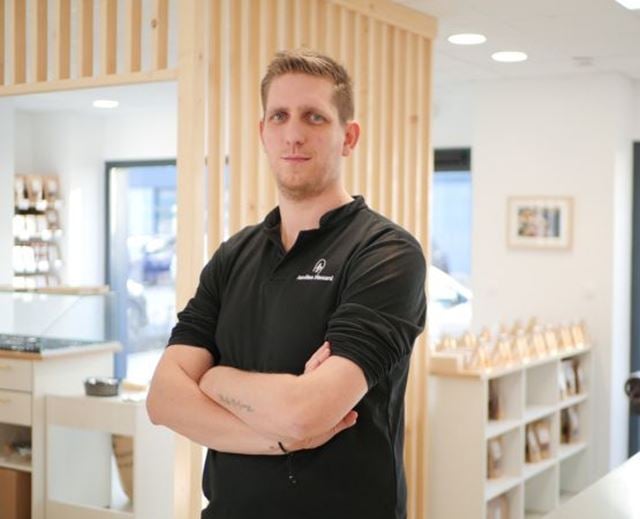 Portrait du chocolatier artisan Aurélien Plassard, bras croisés dans son atelier.