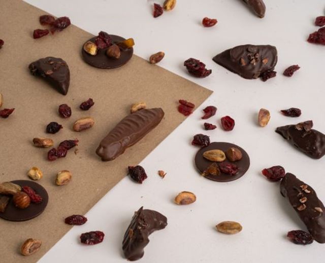 Assortment of dark chocolate creations topped with dried fruit, nuts and cranberries.