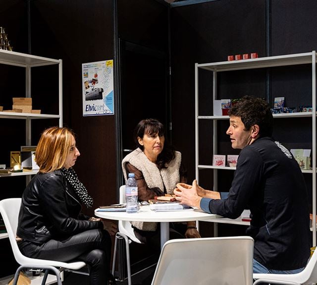 Discussion entre un exposant et un acheteur professionnel lors du Salon du Chocolat.