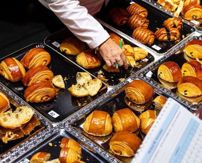Pastry competition featuring chocolate croissants displayed on trays during a professional event