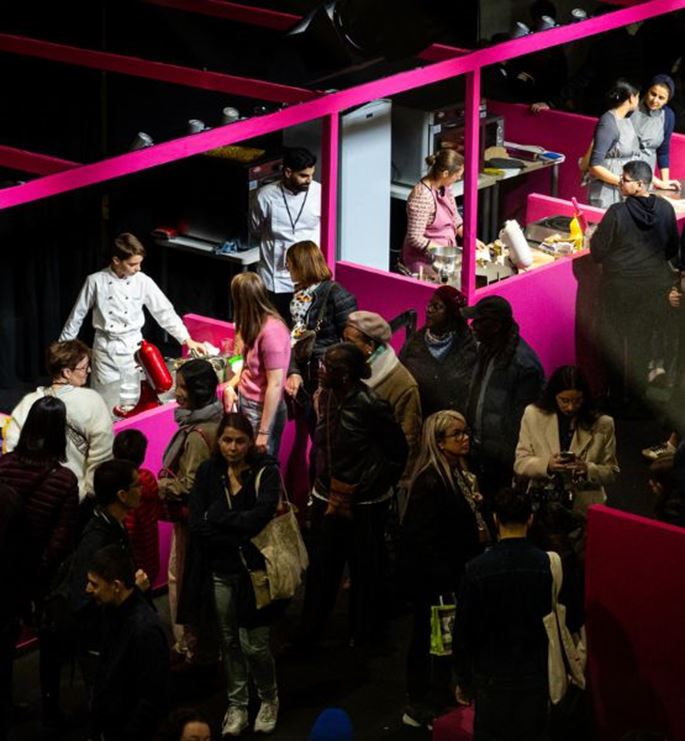 Interactive culinary workshop with chefs and visitors participating in cooking demonstrations at a vibrant booth at the trade show