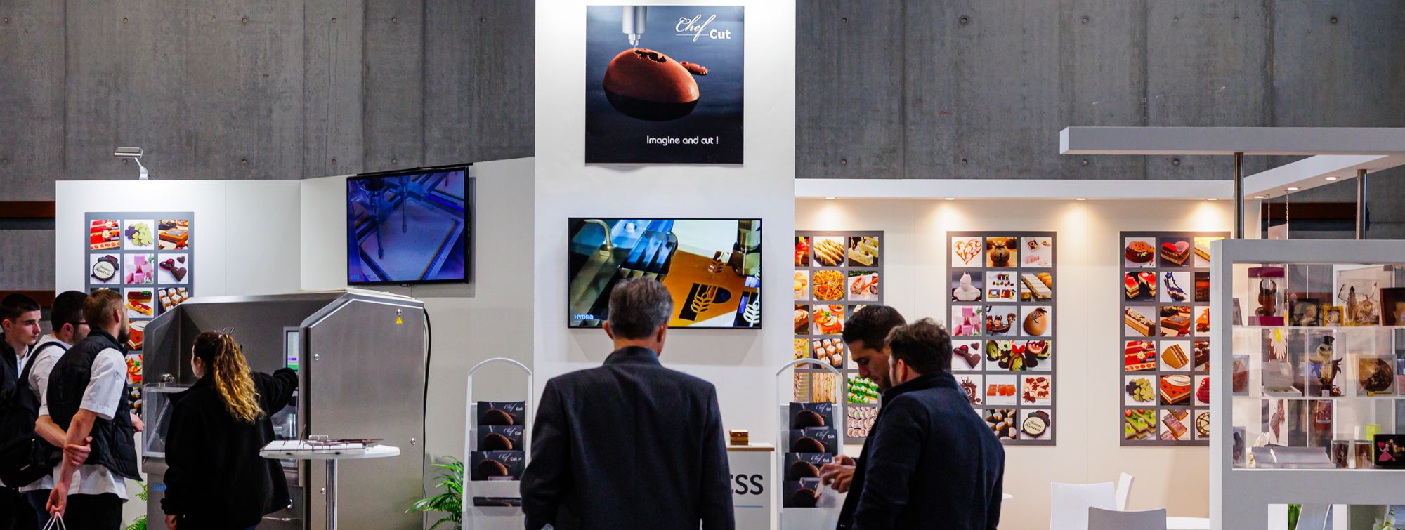 Stand in the BtoB Village with an exchange between an exhibitor and a visitor.